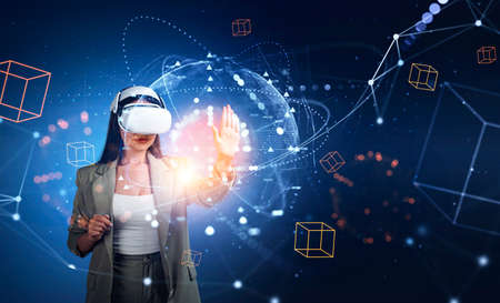 Businesswoman in vr glasses hand touch digital hologram. Metaverse and futuristic technology. Earth...