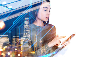Young attractive businesswoman wearing casual wear is holding smartphone. New York city skyscrapers...
