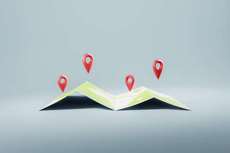 Red location geotag over world paper map on gray background. Concept of navigation, gps and international flights, 3D renderingの写真素材
