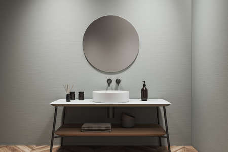 Front view on bright bathroom interior with round mirror, sink, liquid soap, towels, walls and oak wooden hardwood floor. Concept of hygienic and spa procedures for health. 3d renderingの写真素材