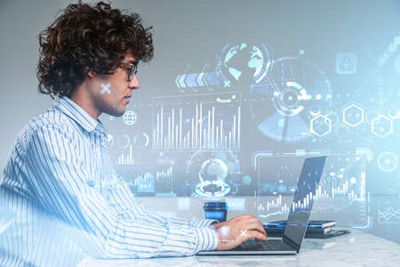 Handsome businessman wearing white shirt is working on laptop with digital interface with icons of...