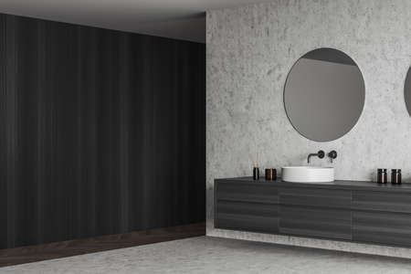 Modern bathing room interior with sink and round mirror, side view, gray concrete floor. modern hotel room. Copy space empty black wooden wall, 3D renderingの写真素材