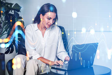 Businesswoman smiling using laptop in office room. Stock market changes, forex candlesticks virtual...
