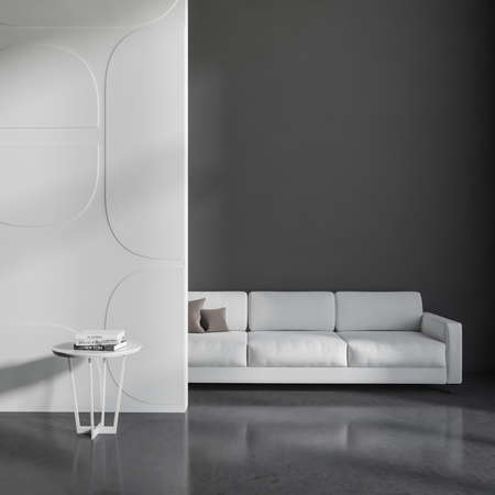 Front view on office room interior with empty gray wall, cozy sofa, coffee table with books and...