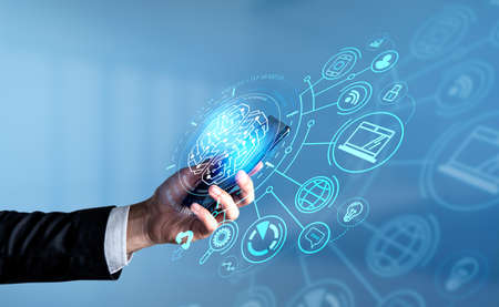 Businessman in formal suit is holding smartphone with digital interface with virtual brain, globe,...
