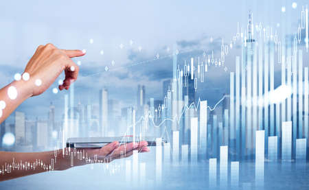 Businesswoman is holding smartphone and touching financial graph with finger. New York panorama in...
