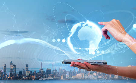 Businesswoman finger touch earth globe, metaverse and virtual reality hologram. Woman hand with smartphone, panoramic cityscape of New Yorkの写真素材
