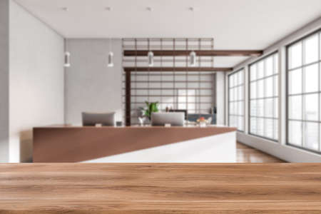 Wooden desk on background of modern reception room interior with pc computer. Panoramic window with city view. Mockup copy space for product placement. 3D renderingの写真素材