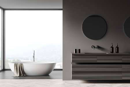 Modern bathroom interior, bathtub and sink with wooden dresser, accessories and round mirror, front...