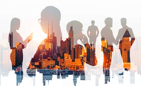 Silhouettes of diverse business people working together, talk and handshake, double exposure with New York city skyline at sunset. Concept of deal and teamworkの写真素材