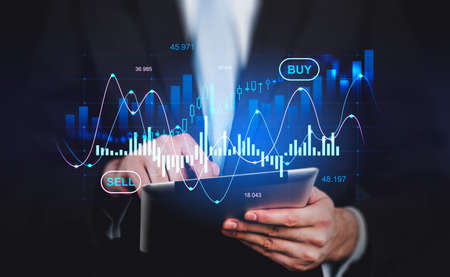 Businessman finger touch tablet in hands, stock market diagrams, hologram with lines and...
