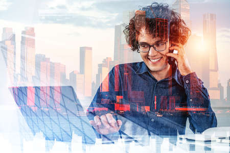 Businessman smiling portrait talking on the phone, working with laptop, double exposure with New...