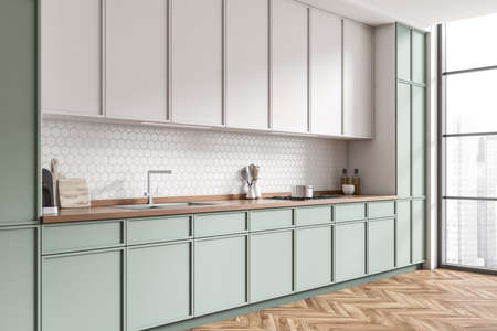 Stylish kitchen interior with deck and sink, stove and kitchenware with dishes, side view. Panoramic...
