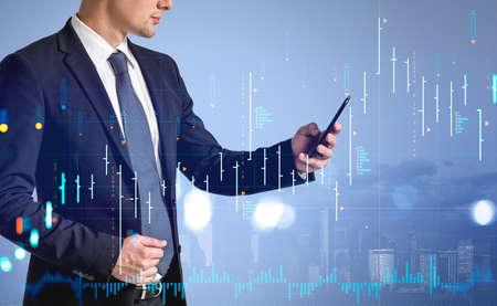 Businessman using phone, New York cityscape on background. Stock market diagrams, forex hologram...