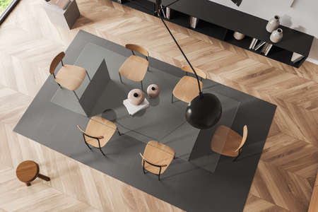 Top view of light living room interior with chairs and glass table on carpet, hardwood floor. Shelf...
