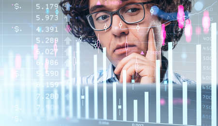 Businessman thoughtful portrait, thinking finger to chin, hud hologram with stock market candlesticks and chart with numbers, double exposure. Concept of risk managementの写真素材