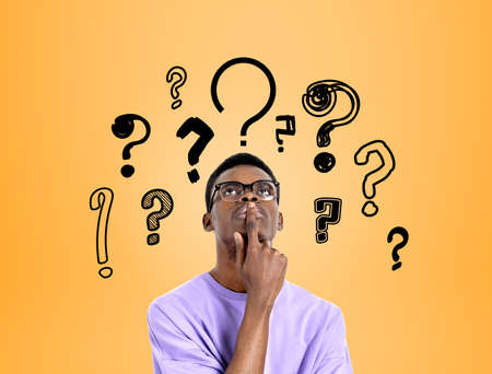 African american man with finger to mouth, serious and thoughtful look. Background of doodle...