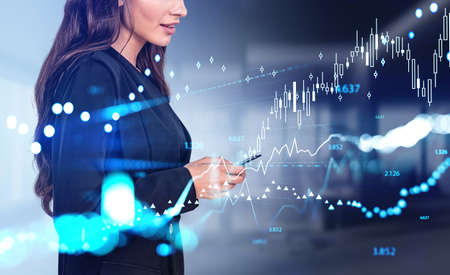 Smiling businesswoman with smartphone in hands, forex hologram. Digital financial hud with bar chart...