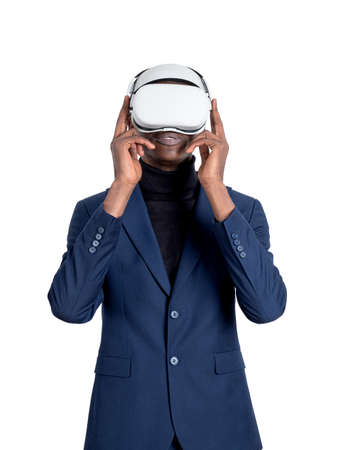 African businessman wearing vr glasses headset, isolated over white background, blue suit. Concept...