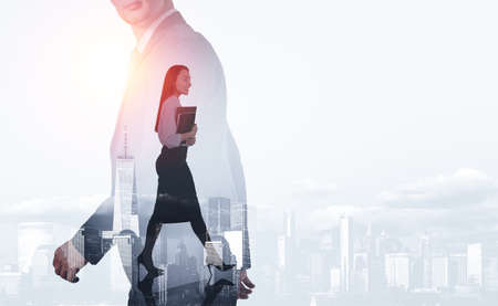 Businessman and businesswoman walking, two people silhouette walking, double exposure, New York skyline. Concept of communication and teamworkの写真素材