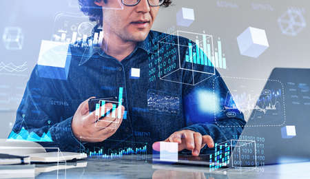 Businessman working with laptop and smartphone. Digital hologram with forex diagrams, binary and...