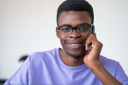African businessman smiling portrait calling on the phone, happy look on white background. Concept...