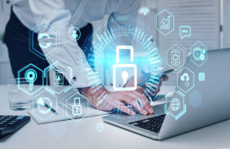 Businessman hands using smartphone and laptop in office room. Personal and business data protection, digital glowing network icons. Concept of cyber securityの写真素材
