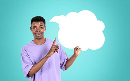 African American businessman wearing casual wear is standing pointing up with fingers to speech...