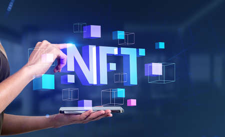 Woman finger touch phone and digital blocks with NFT neon digital hologram. Cryptoart and token create. Concept of virtual artの写真素材