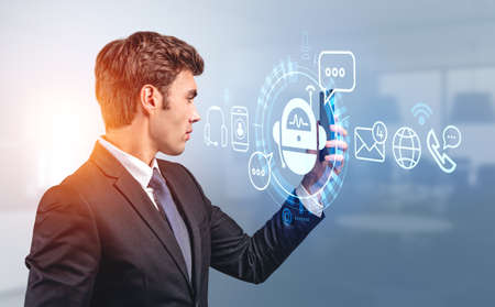 Businessman profile holding smartphone in hand, hologram of voice chat bot. Social network icons and...