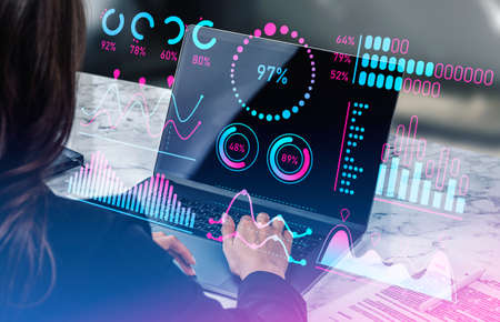 Businesswoman hand typing on laptop computer. Virtual screen with stock market analysis hud, forex graphs with numbers. concept of investmentの写真素材