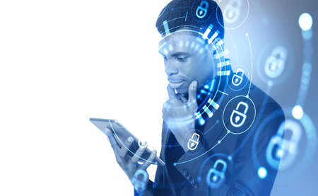 Black businessman with tablet in hands, pensive look with hand on chin. Double exposure with glowing...