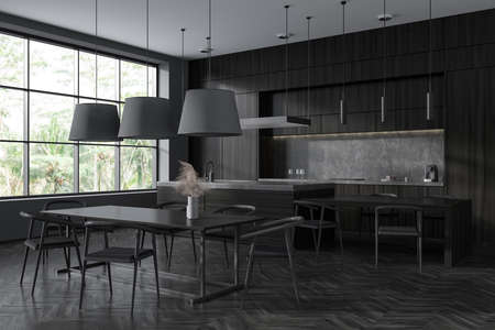 Black kitchen interior with chairs and bar island, side view, hardwood floor. Kitchenware on deck,...