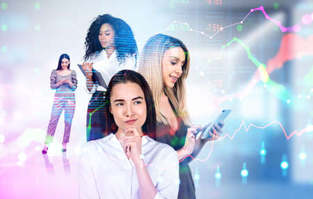 Multinational businesswomen using smartphone and taking notes. Double exposure with colorful financial analysis hologram, stock market chart with candlesticks. Concept of conferenceの写真素材