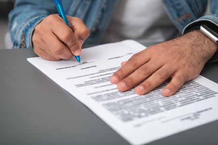 Businessman wearing casual wear is sitting signing contract at office workplace in background. Concept of working process, important profitable deal, business partnership agreement. close up viewの写真素材