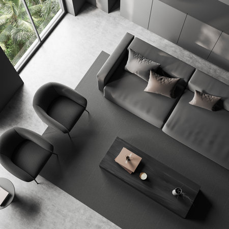 Top view of dark living room interior with sofa and two armchairs, coffee table with decoration,...