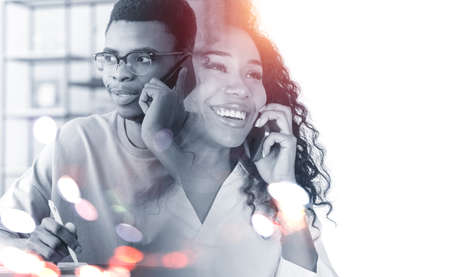 Smiling attractive businesswoman wearing formal wear is talking to businessman on phone discussing...