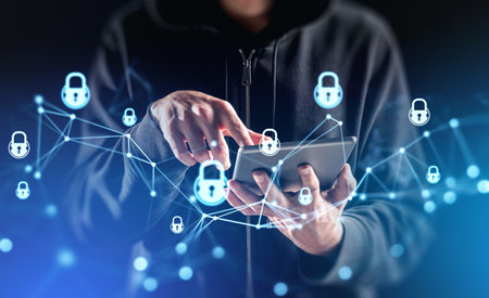 Hooded man hacker finger touch tablet in hand, double exposure glowing lock circuit connection. Concept of cyberattack and global protectionの写真素材