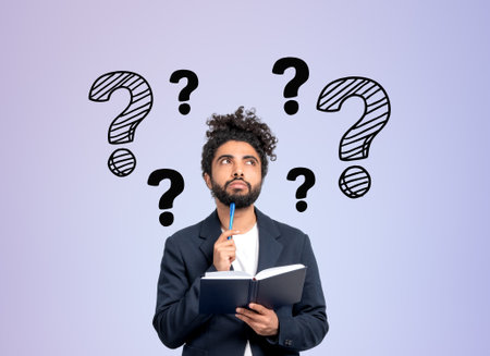Middle eastern businessman with notebook and pen to chin, searching for answers. Doodle question...