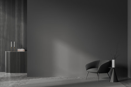 Front view on dark living room interior with armchair, empty gray wall, concrete floor, coffee table, closet with books and candles, carpet. Concept of minimalist design. 3d renderingの写真素材