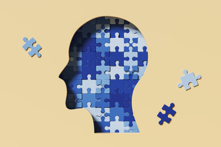 Human head made of different blue puzzle pieces, beige background. Concept of mental health and...