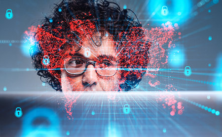 Attentive handsome curly businessman in glasses working on laptop. Digital interface with red map...