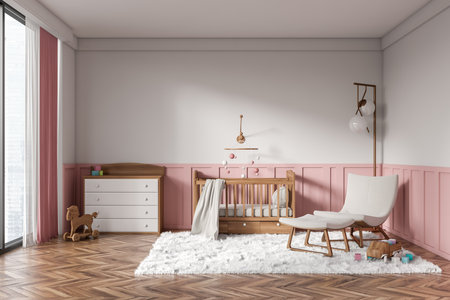 Front view on bright baby room with child bed, armchair, pink and white wall, oak wooden hardwood floor, panoramic window. Concept of nursery in soft design, cozy space for newborn kid.の写真素材