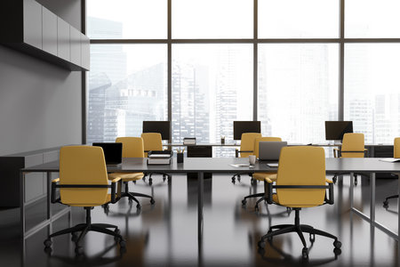 Dark office interior with table, armchairs and laptop. Coworking zone with pc computer in row near panoramic window on Singapore skyscrapers. 3D renderingの写真素材