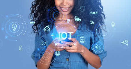 African American businesswoman wearing formal wear typing on smartphone standing at blue background. Digital interface with iot. Concept of modern technology, business automation and developmentの写真素材