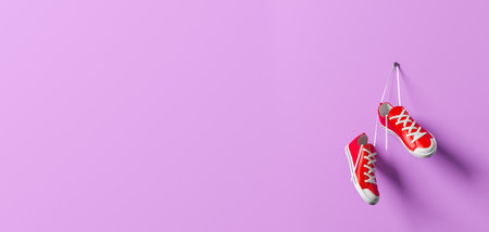 Pair of red sneakers hanging on a white lace, empty copy space purple banner. Concept of training, running and sports fashion shoes. 3d rendering, illustrationの写真素材