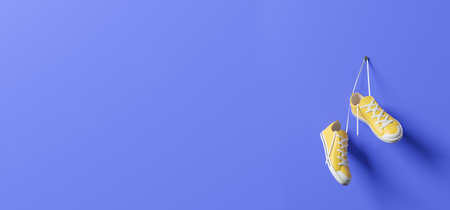Bright yellow and white sneakers hanging on blue wall. Concept of sport and active lifestyle. 3d rendering, mock upの写真素材