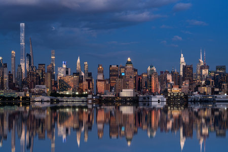 Skyline of New York city and its reflection in water at night. New York, the United States of...