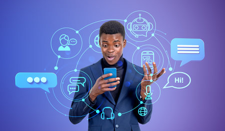 African businessman working with Chatbot in phone. Chat bot hologram icons, using AI to speed up...