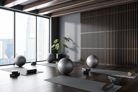 Dark yoga gym interior with mat and fitball with block and roller, side view hardwood floor. Sport class room with equipment and panoramic window on Kuala Lumpur. 3D renderingの写真素材